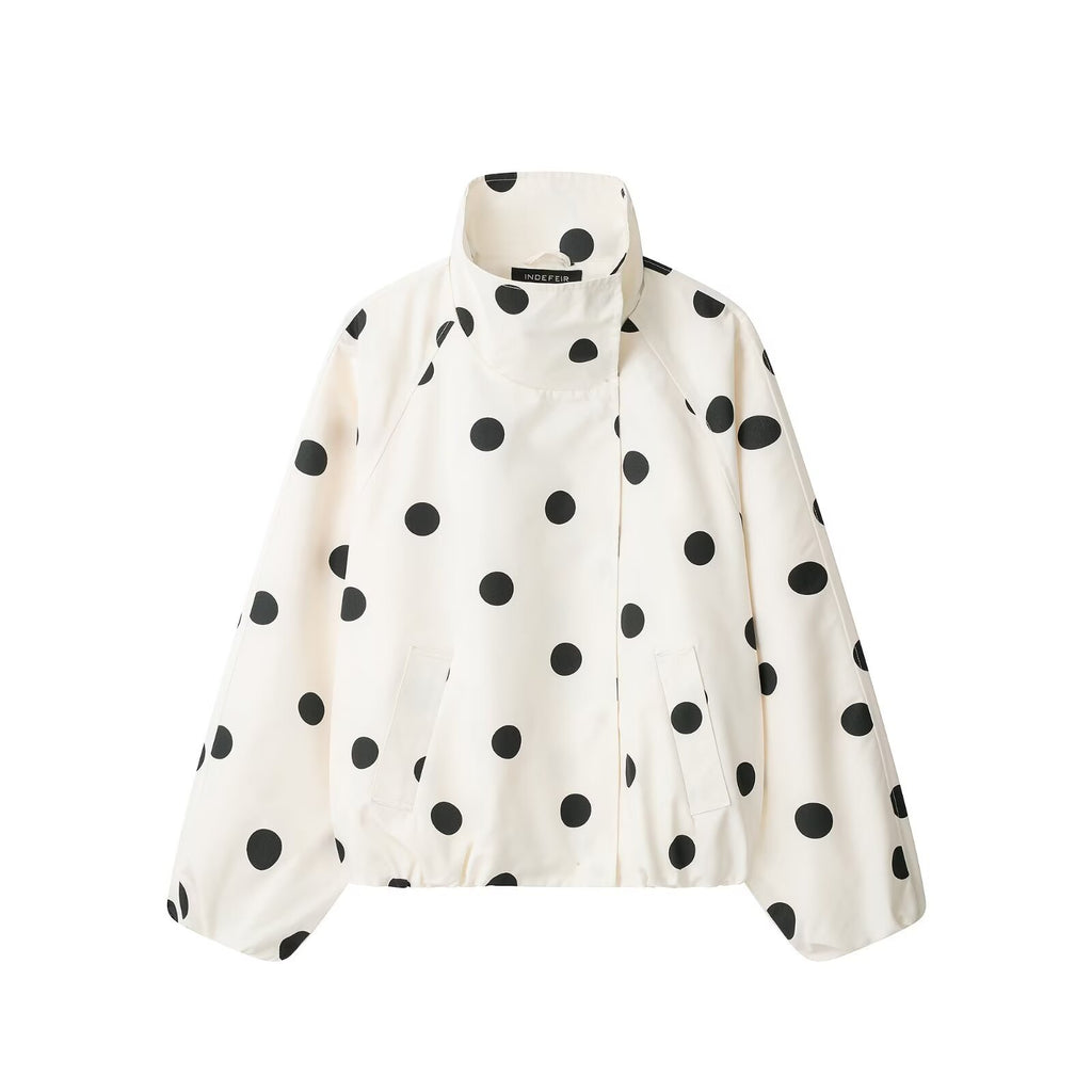 Close-up detail of white polka dot turtleneck jacket — collar and fabric