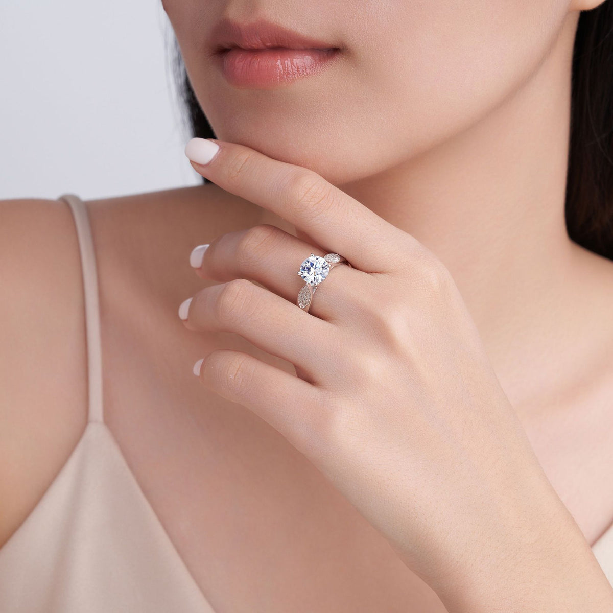 Leaf design moissanite ring worn on hand showing 8mm centre stone and pave leaf accents