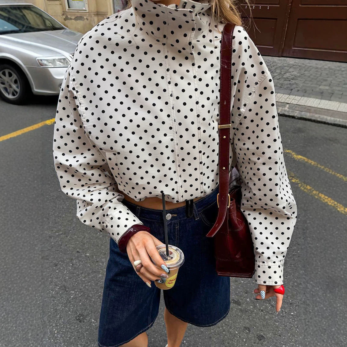 Polka dot cropped jacket in white – on model front view showing stand-up collar detail and zip front fastening
